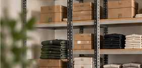 Organized stockroom shelves with boxed and folded retail inventory
